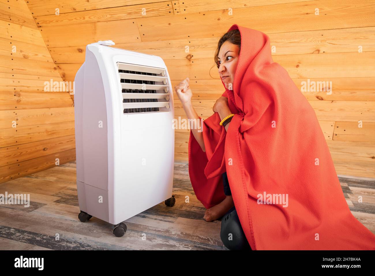 The electric heater broke down in winter and does not turn on. An angry woman freezes and hits