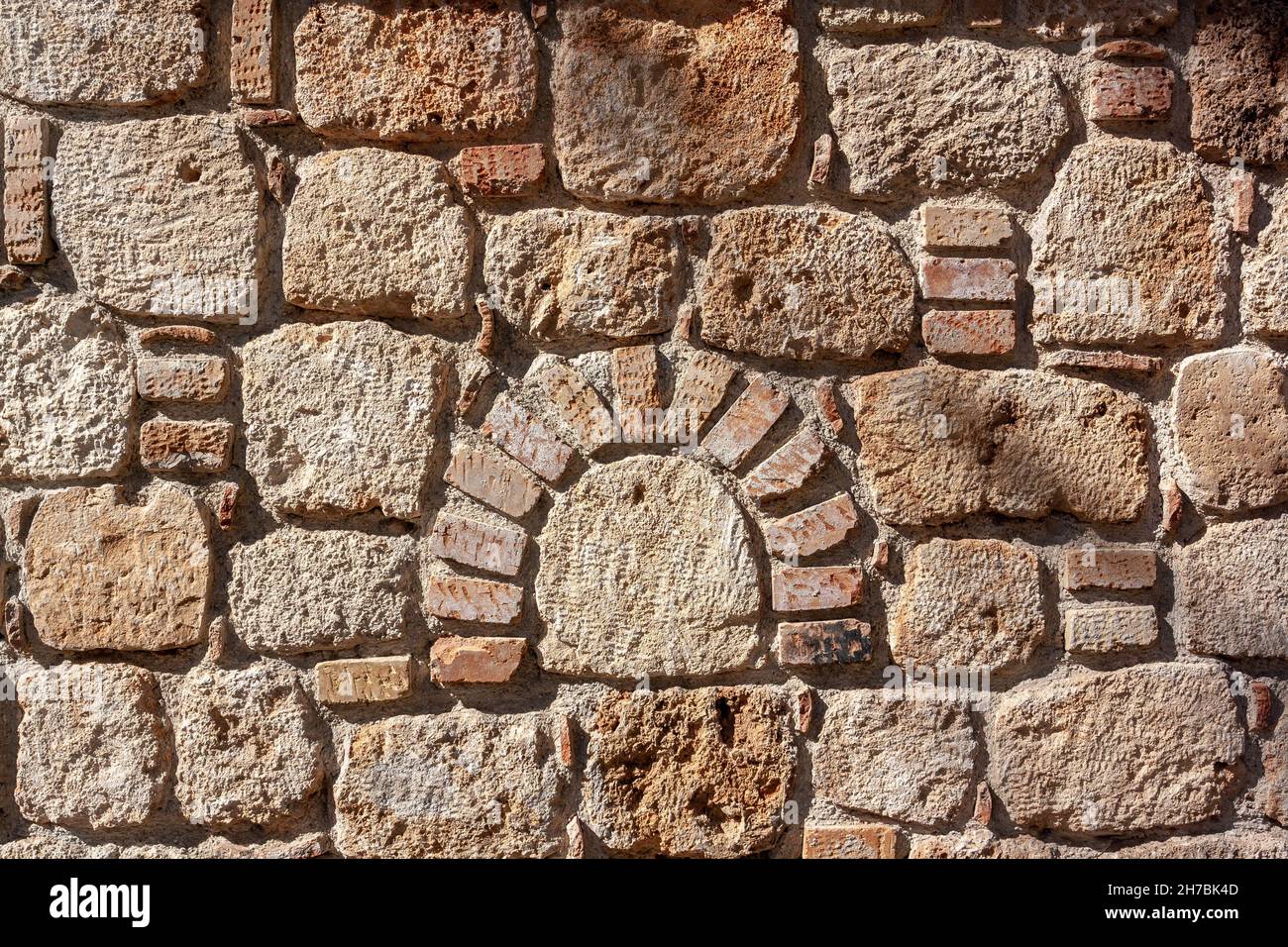 Figured old masonry made of blocks of different sizes in cement mortar. Stock Photo