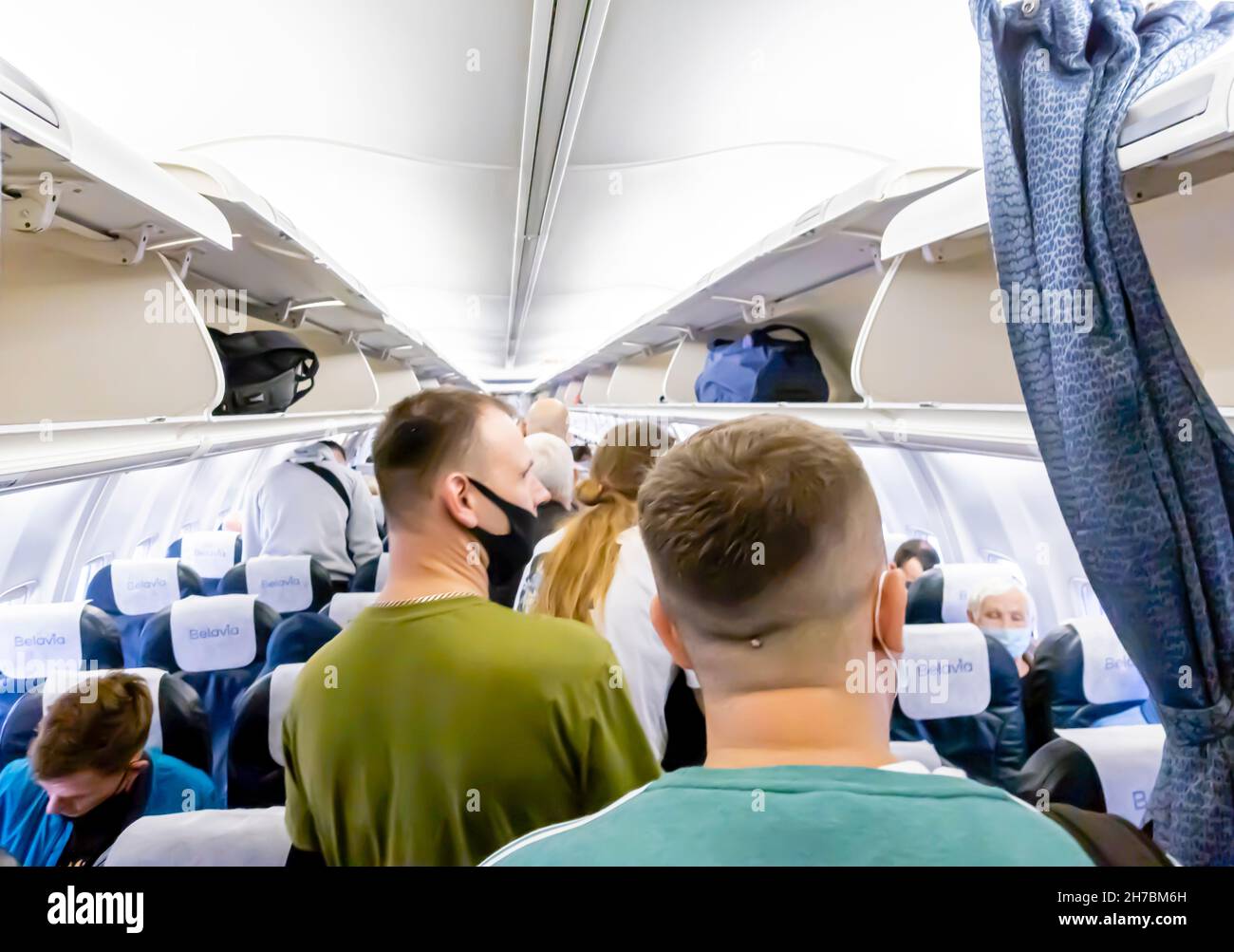 Passengers in face masks leaving a Belavia Boeing 737800 plane Stock