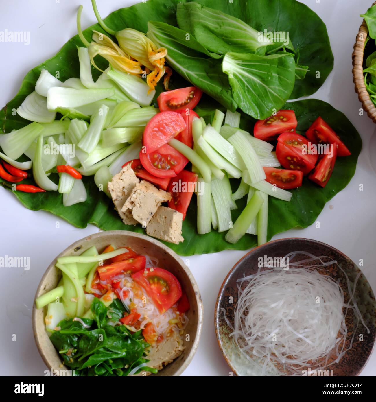 Vietnamese green vegetables hot pot, tomato, bok choy, tofu skin, colocasia gigantea with