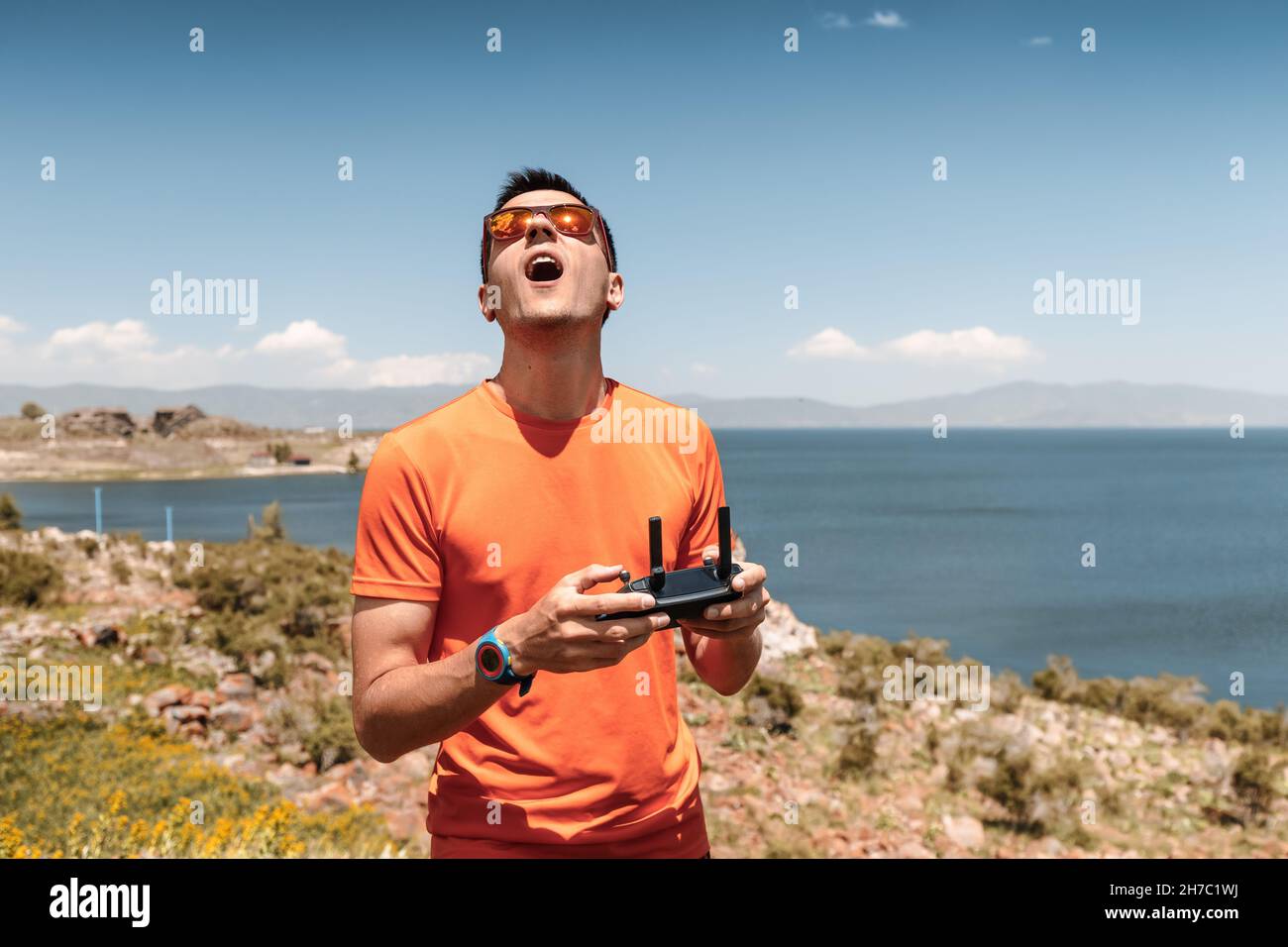 Man photographer or videographer as a pilot of uav. Flight of a quadcopter or drone using a wireless remote control over a radio channel Stock Photo