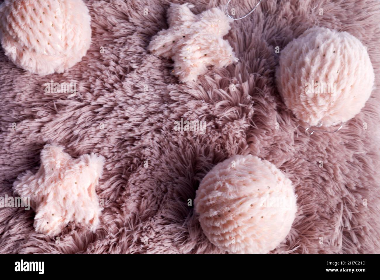 Christmas background with pink fur balls on pink fur background. Winter holidays background. Winter mood Stock Photo