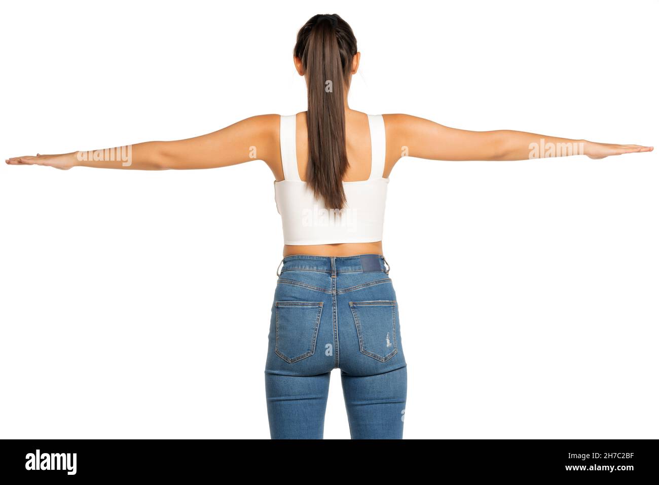 rear view of a young beautiful woman with outstretched arms and ponytail on a white background Stock Photo