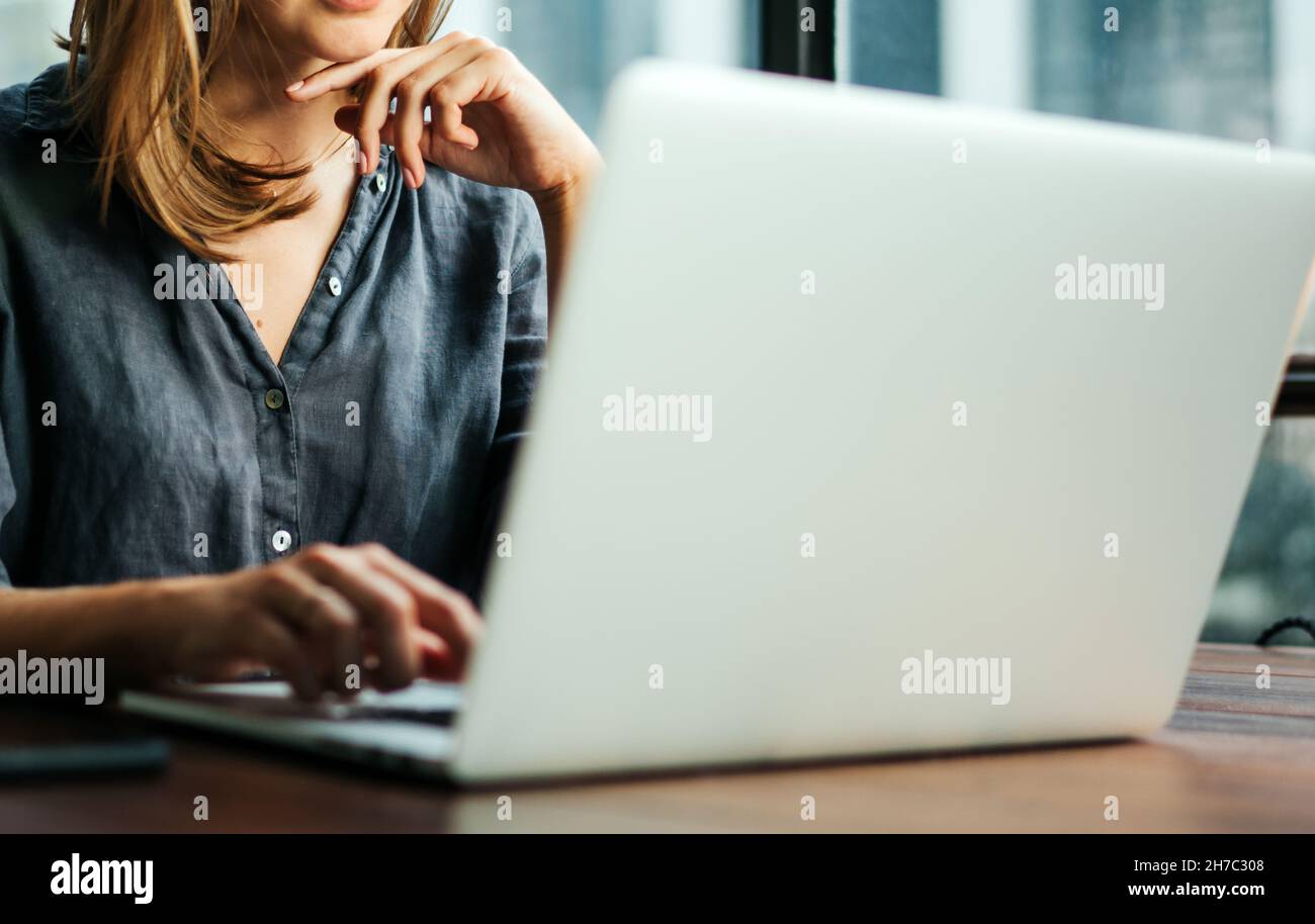 Young woman working with a laptop. Female freelancer connecting to ...
