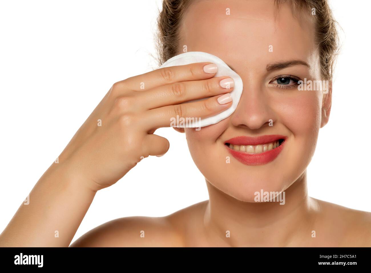 Young Happy Blond Woman Using Cotton Pad To Remove Makeup On White
