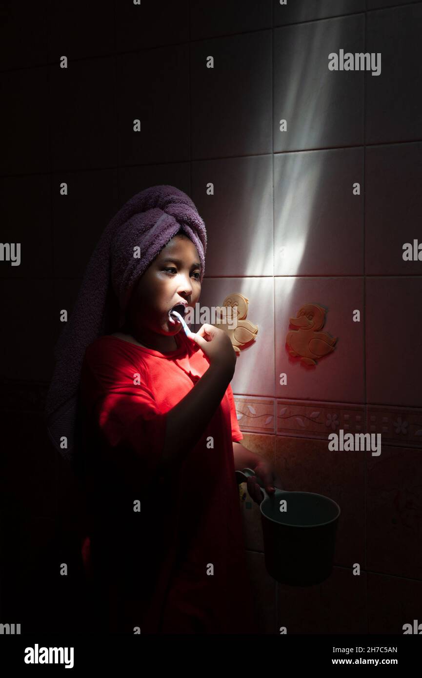 Indonesian child brushing her teeth in the bathroom. Stock Photo