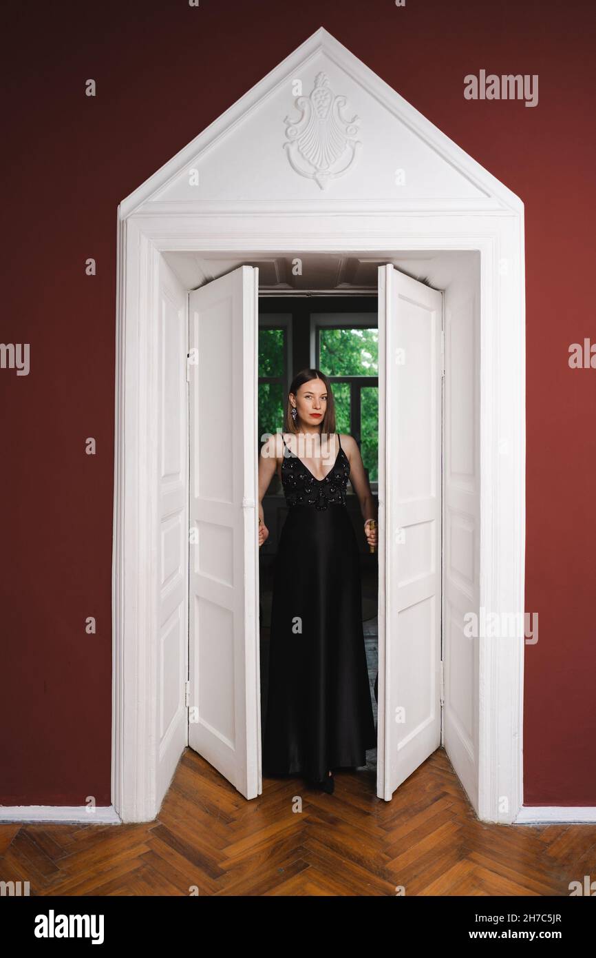 Beautiful woman model dressed in an elegant long black dress in a ...