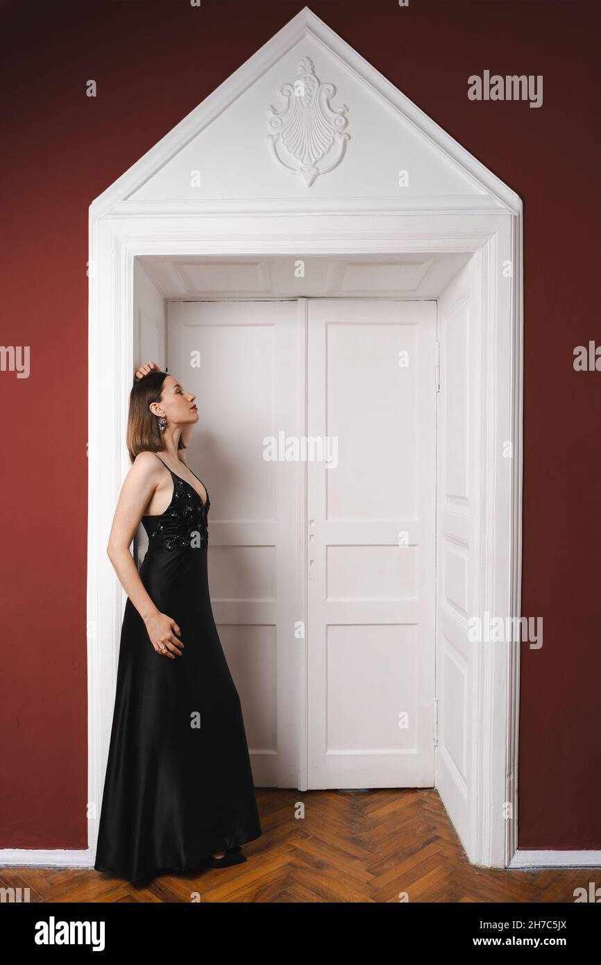 Beautiful woman model dressed in an elegant long black dress in a ...