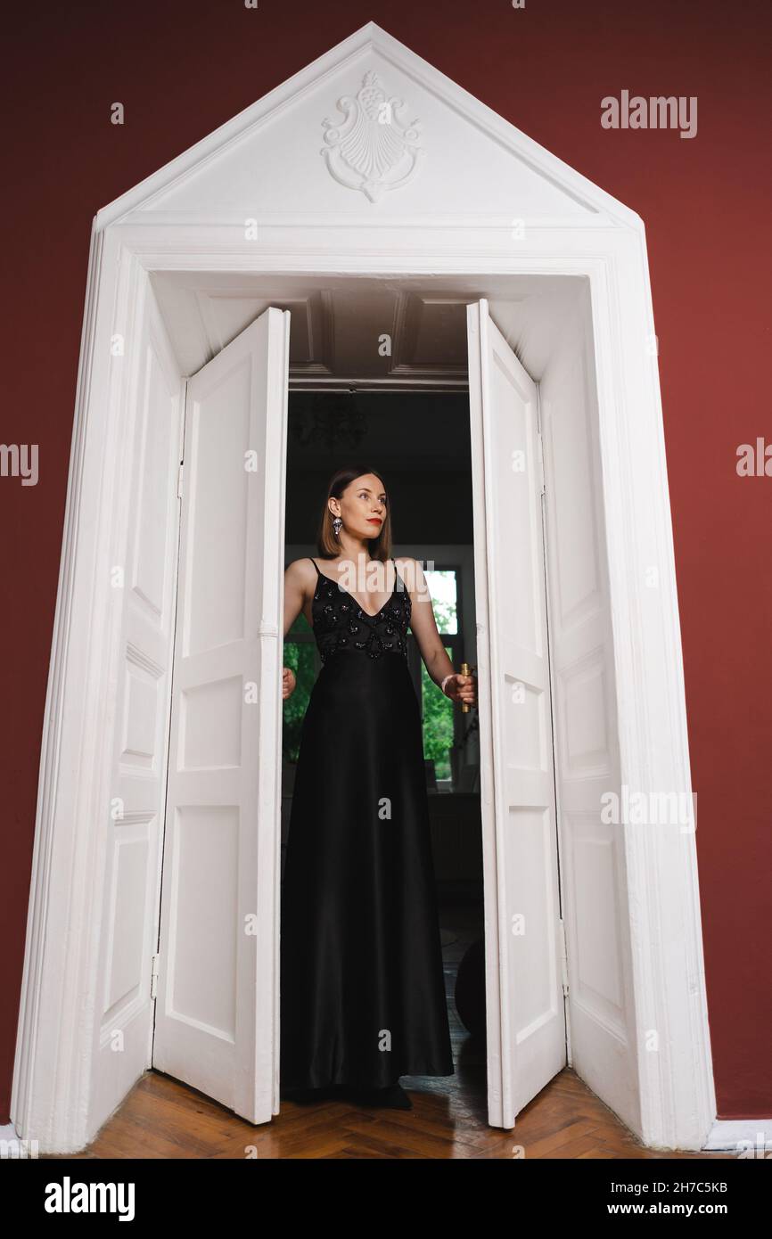 Beautiful woman model dressed in an elegant long black dress in a ...