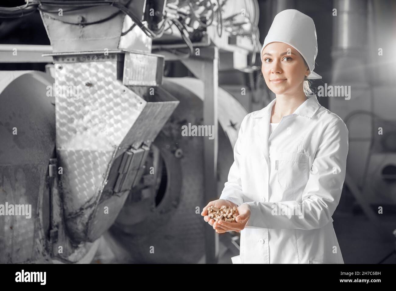 Mill worker holds finished products of wheat bran in background of