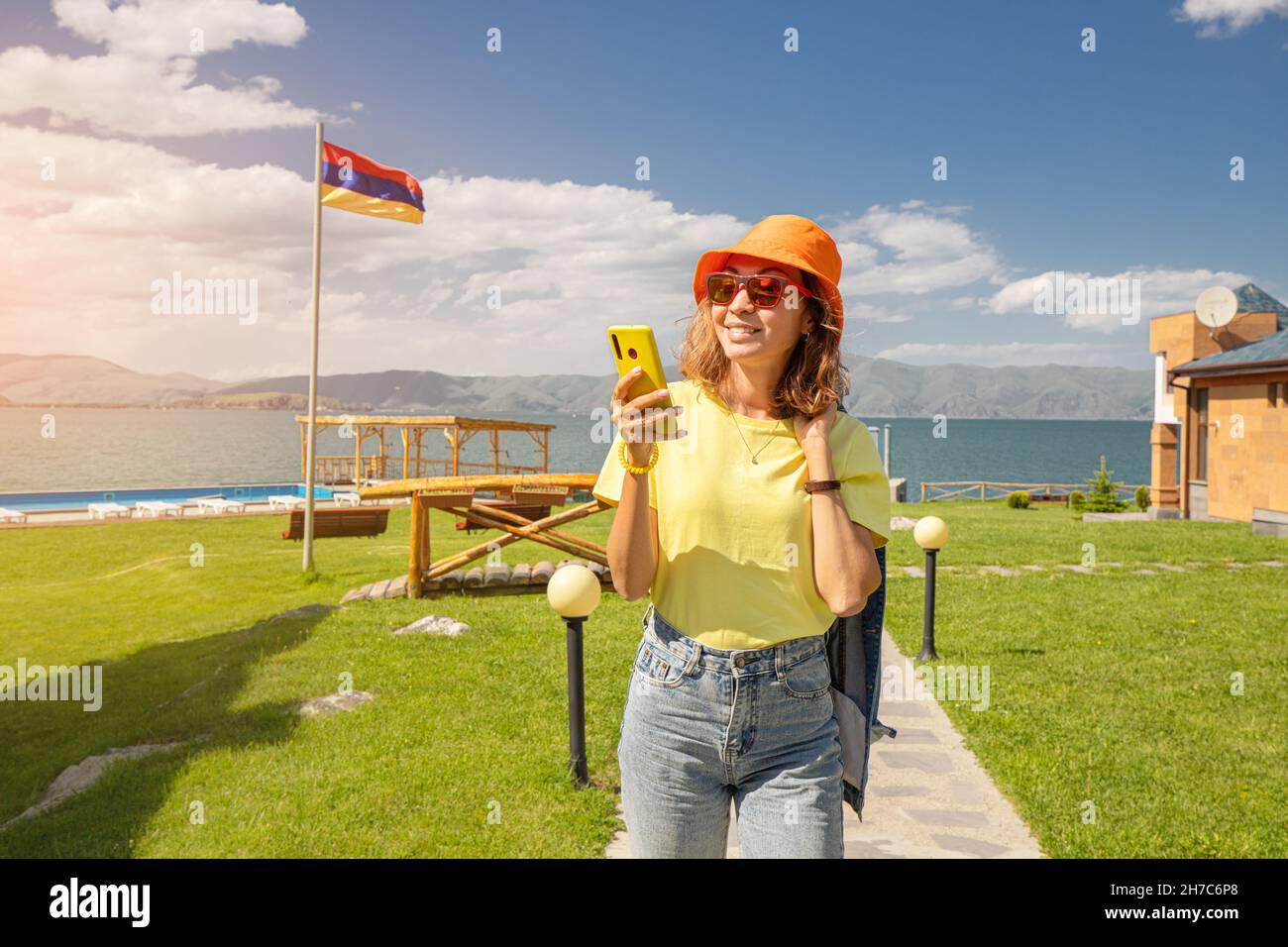Happy woman walking by the wonderful views of the famous Lake Sevan in ...