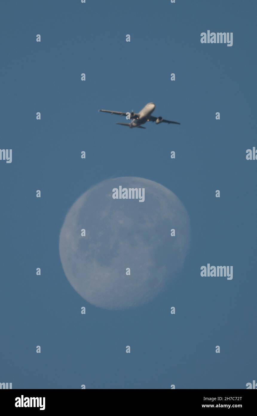 Wimbledon, London, UK. 22 November 2021. An early morning Eurowings flight leaving London Heathrow for Stuttgart crosses the setting Moon on a clear and cold morning. Credit: Malcolm Park/Alamy Live News. Stock Photo