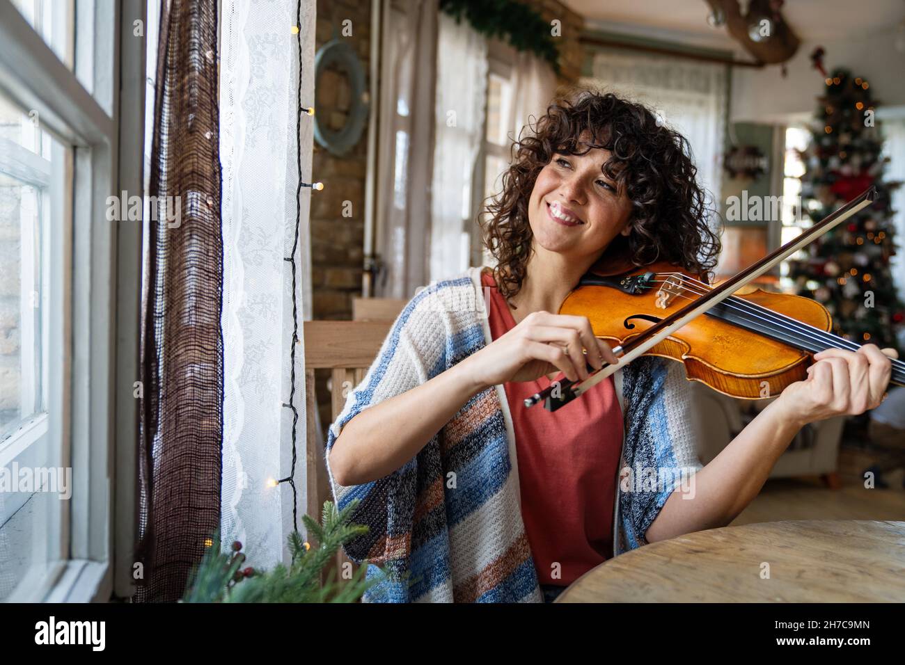 Attractive young woman musician plays the violin practicing musical instrument Stock Photo