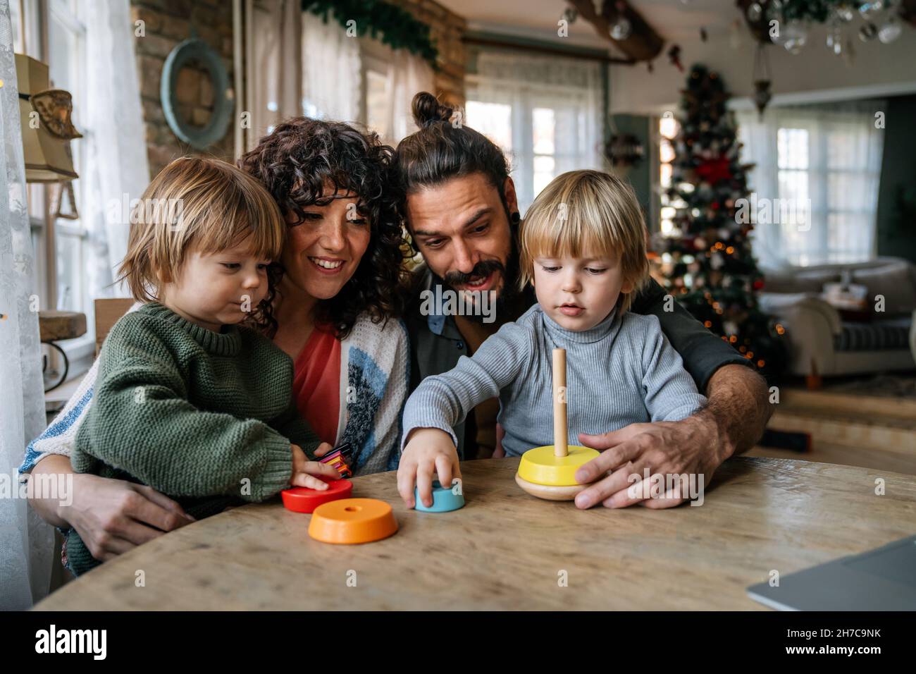 Family and childhood concept. Young parents spending time together with children at home. Stock Photo