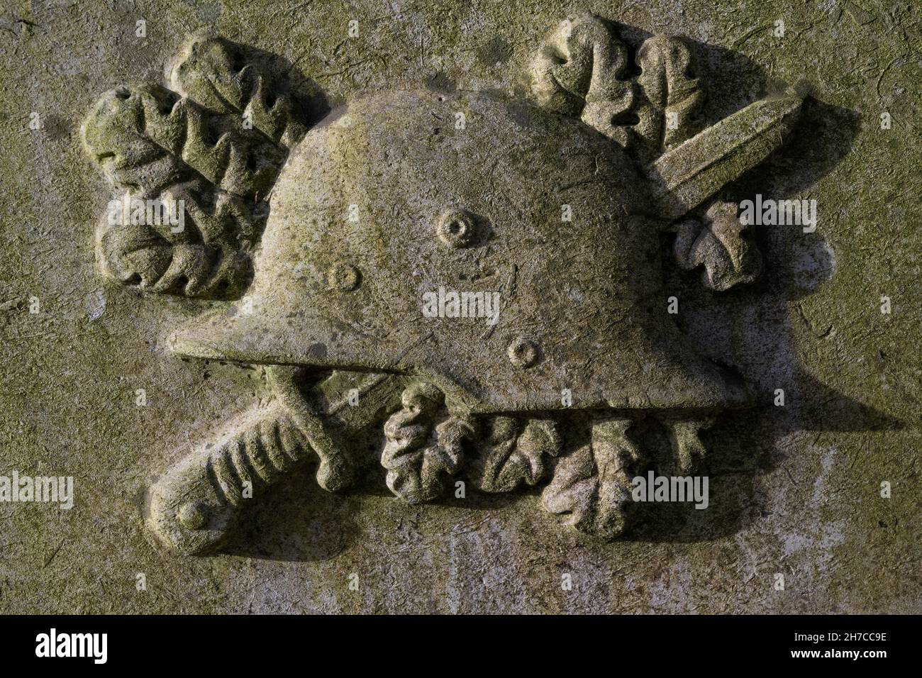 stonemasonry on a world-war-one tomb with german helmet oak leaves and dagger. Stock Photo