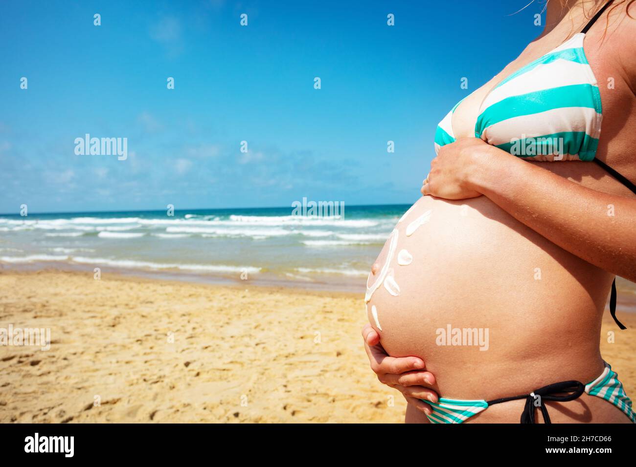 Pregnant belly in bikini next to the sea Stock Photo
