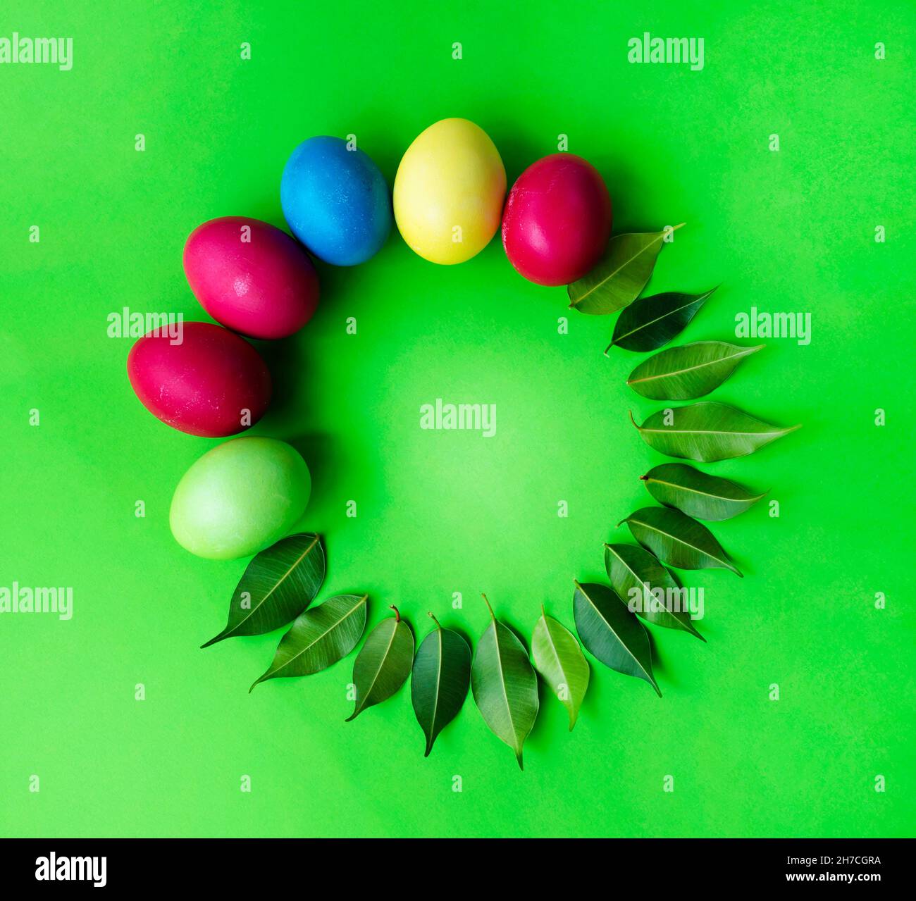 Round Easter rosette for text made from painted eggs and green leaves. Stock Photo