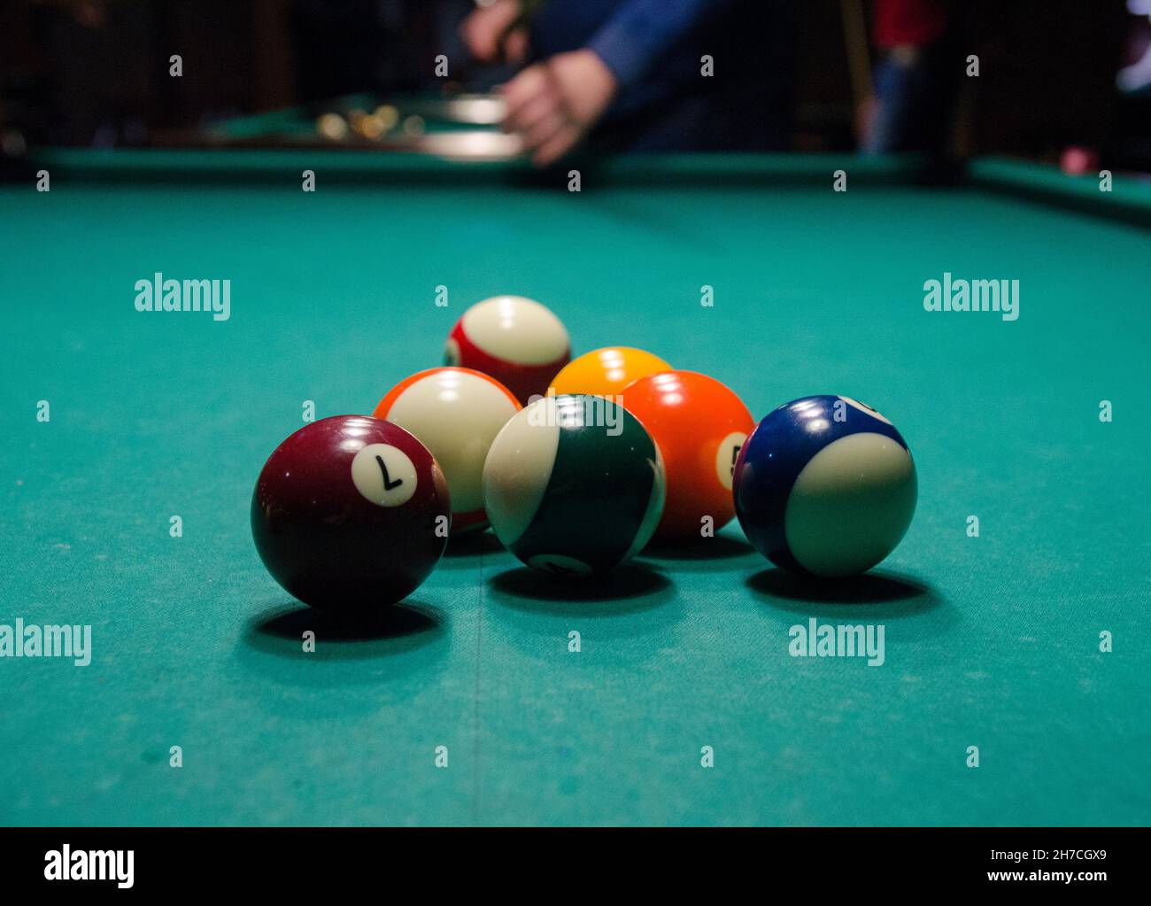 Billiard balls are in the game. Billiard player is getting ready to