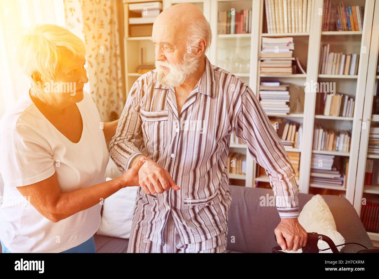 Caregiver helps seniors with dementia with elderly care at home Stock