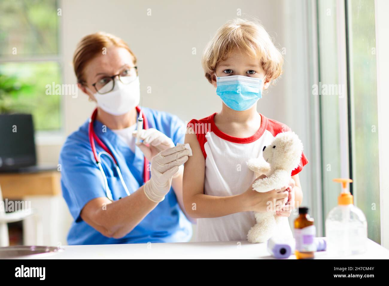 Child getting covid-19 vaccine. Coronavirus vaccination for young kids. Doctor giving kid patient covid shot. Immunization program for adolescents Stock Photo