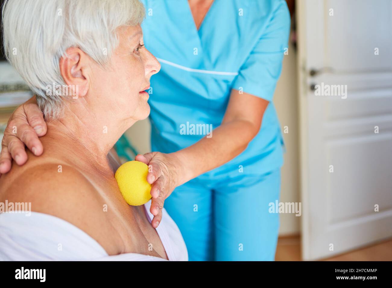 Elderly woman gets a trigger point massage with a small massage ball in the physio Stock Photo