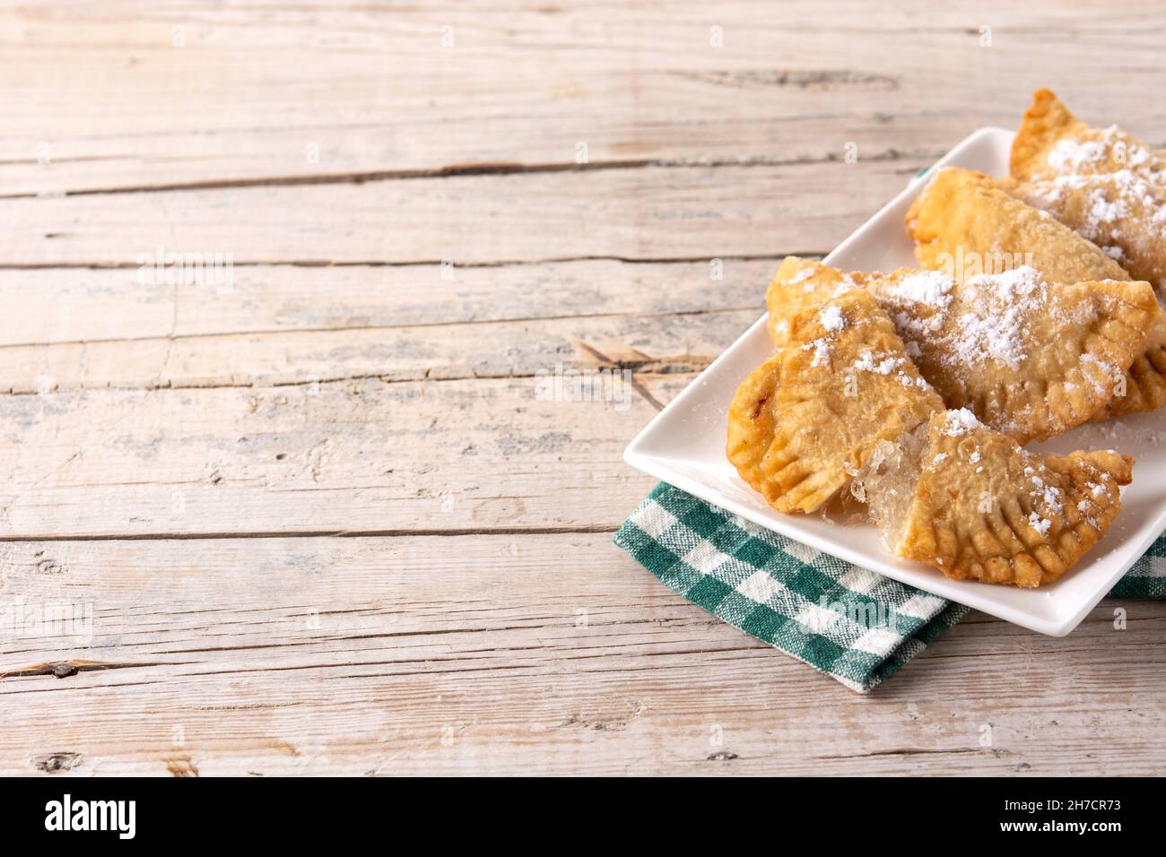Spanish sweet stuffed pastry filled with angel hair on wooden table ...