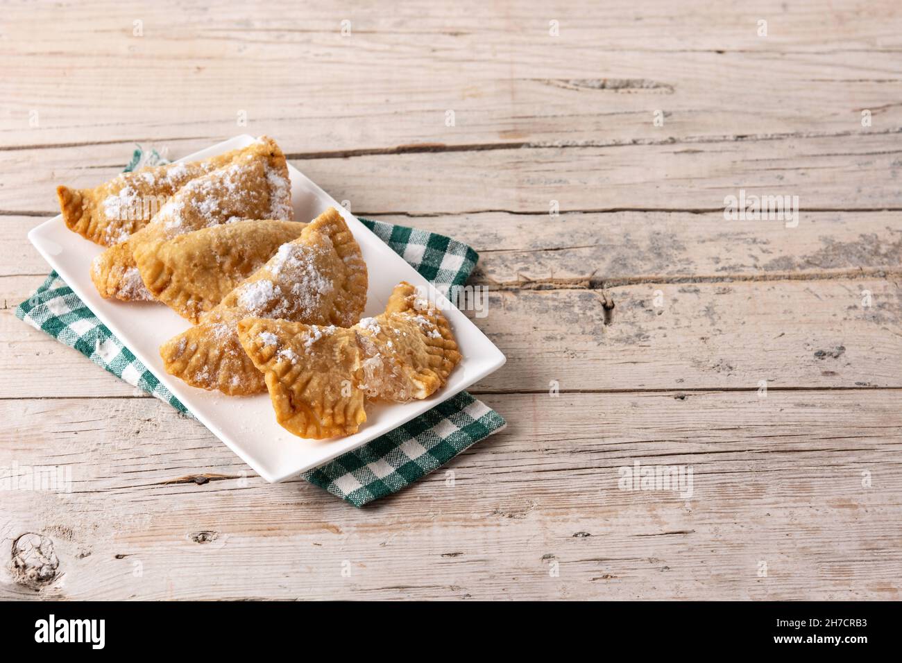 Spanish sweet stuffed pastry filled with angel hair on wooden table ...