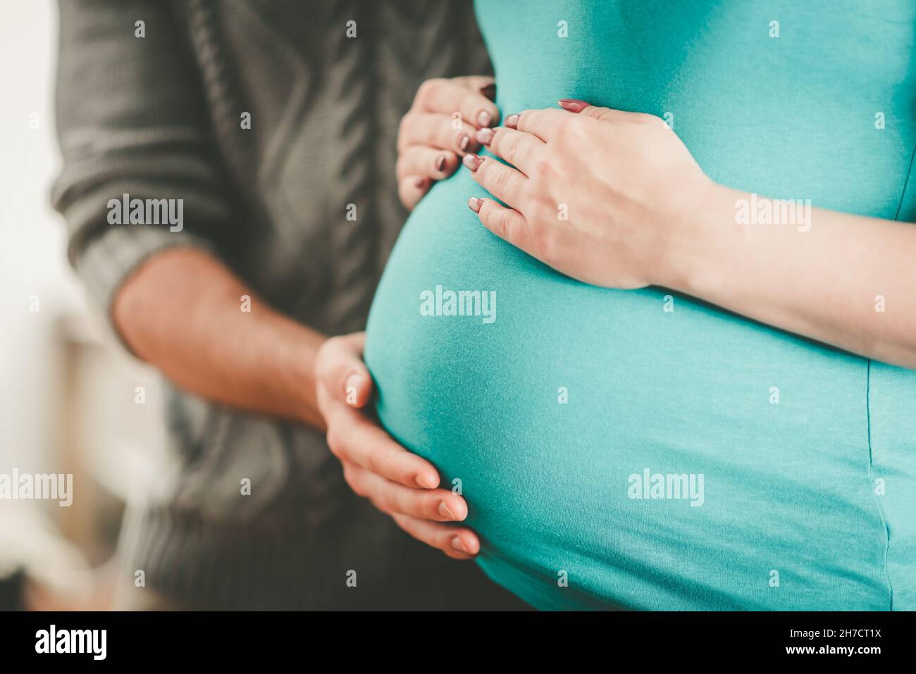 Couple holding hands on pregnant belly Stock Photo Alamy