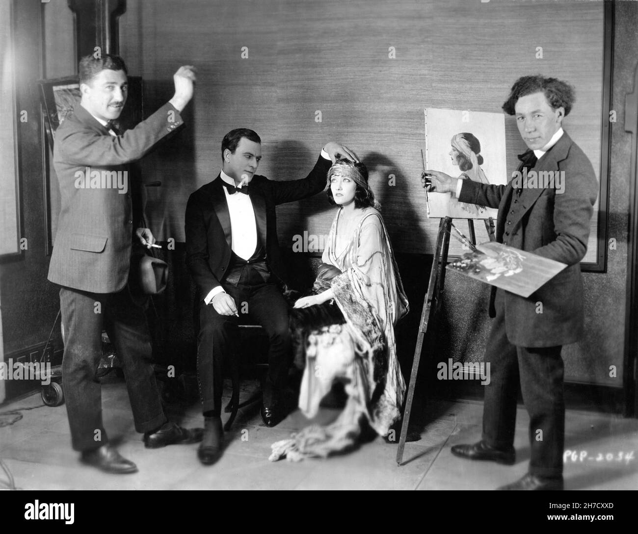 THOMAS MEIGHAN and GLORIA SWANSON on set candid with Artist Painting Portrait during filming of WHY CHANGE YOUR WIFE ? 1920 director CECIL B. DeMILLE story William C. de Mille costume design Clare West and (uncredited) Natacha Rambova Famous Players - Lasky Corporation / Paramount Pictures Stock Photo