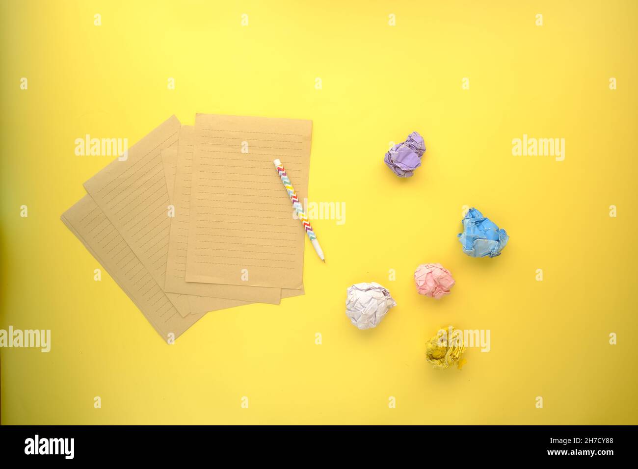 crumpled paper ball and notepad on yellow background  Stock Photo