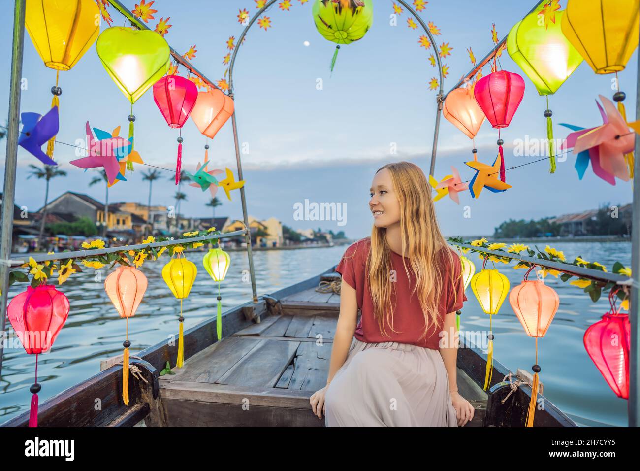 Happy woman traveler ride a national boat on background of Hoi An ...