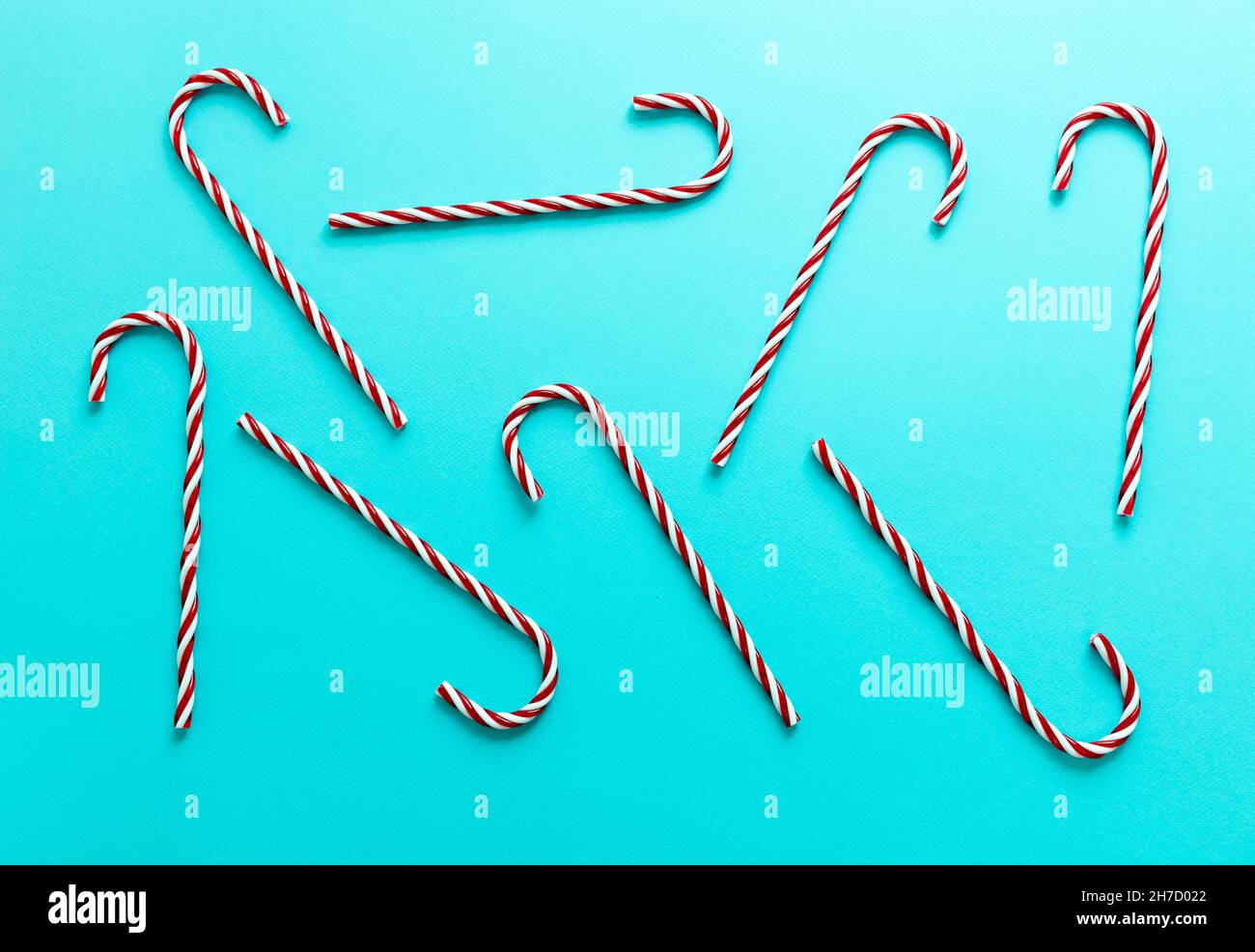 Christmas candy canes on pastel blue background. Merry Xmas concept. Peppermint red white