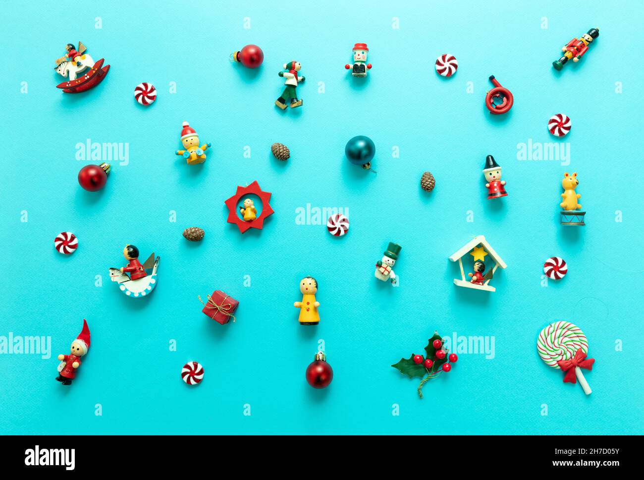 Christmas decoration, small baubles variety on blue color background, minimal Xmas flat lay, top view. Wooden vintage ornaments, kids traditional toys Stock Photo