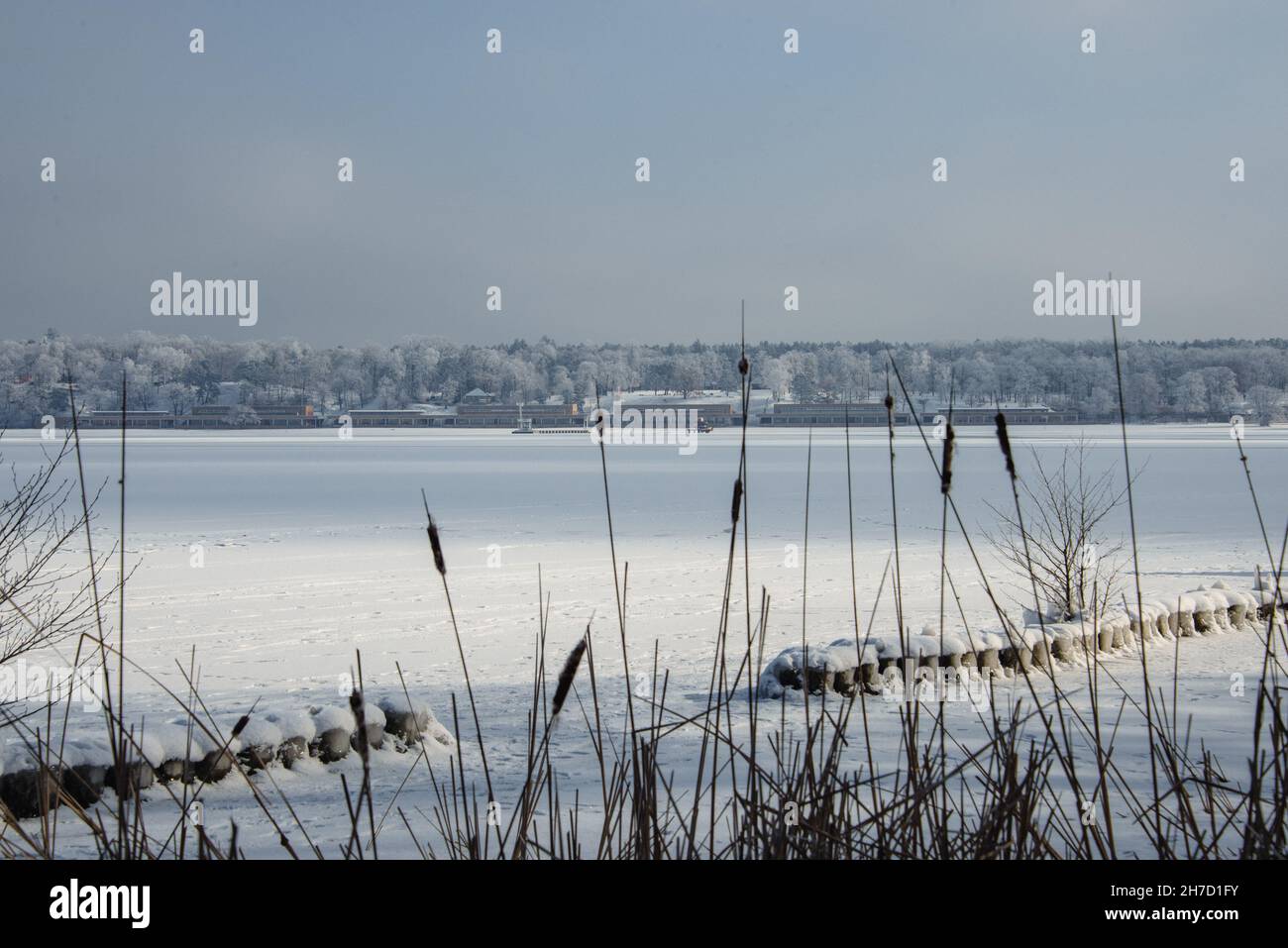 Grey and white: view across frozen lake Wannsee to the historic lido builidings. Stock Photo