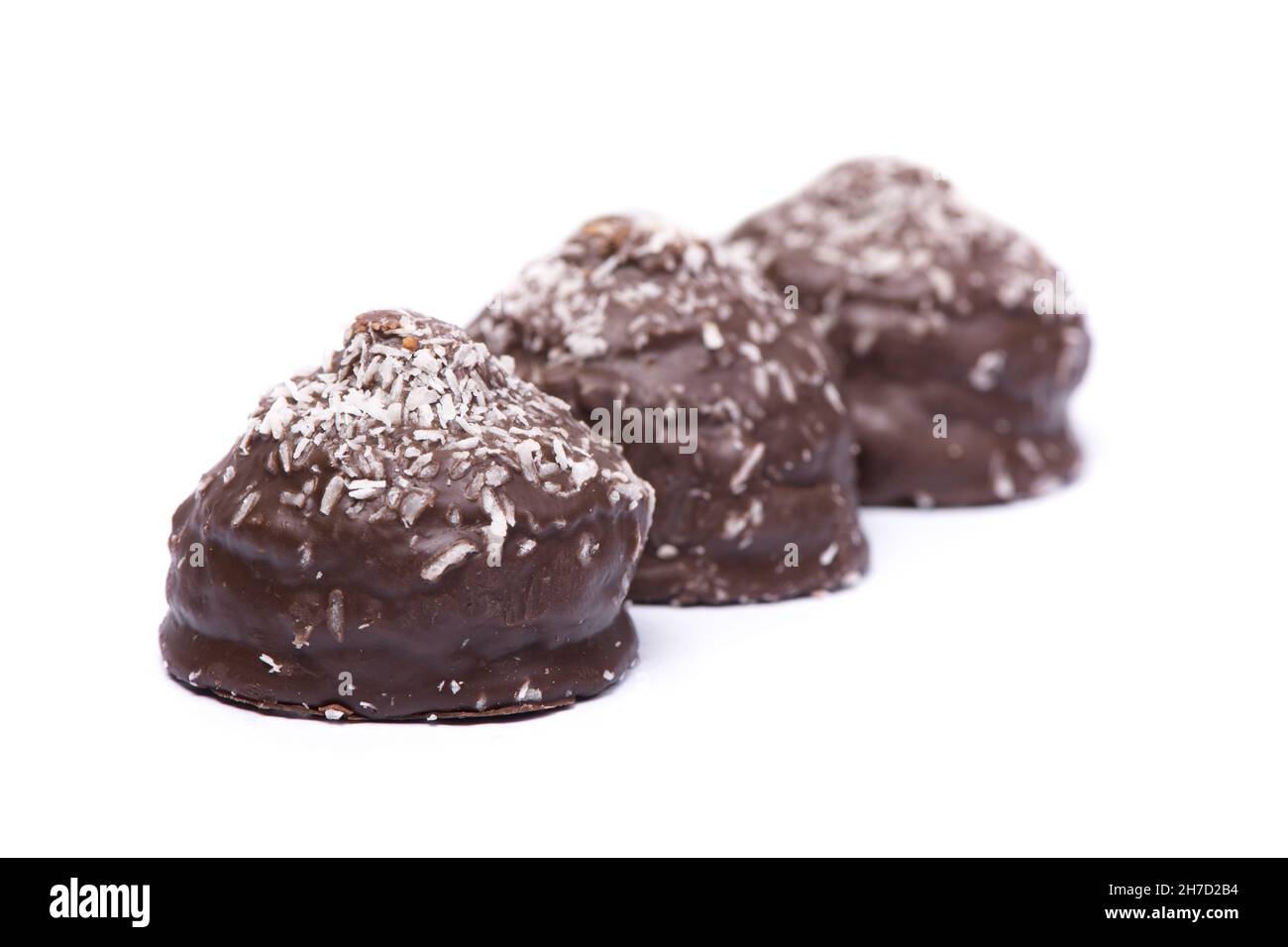 Confectionery, group of chocolate glazed cakes with coconut chips isolated on white background Stock Photo