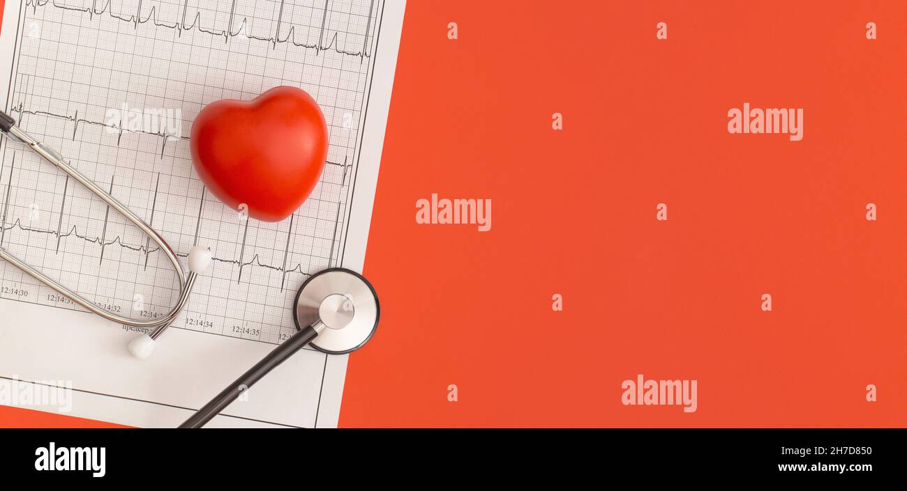 Stethoscope and heart on the background of the cardiogram. Top view ...