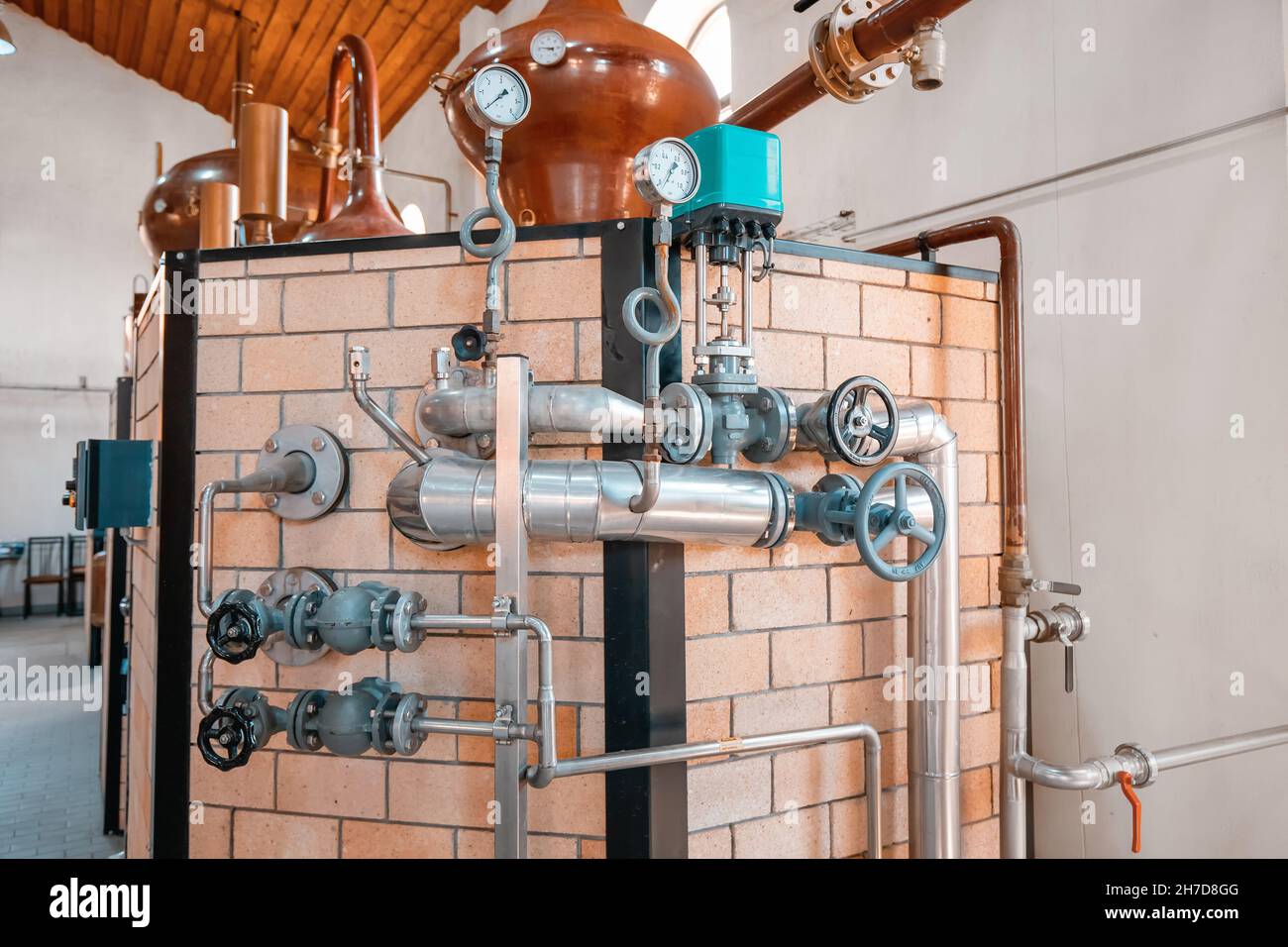 At the distillery plant of strong alcohol. Close-up of pipes with valves and a pressure gauge Stock Photo