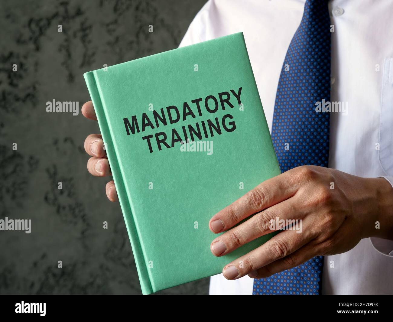 Employee holds mandatory training guide in the hands. Stock Photo