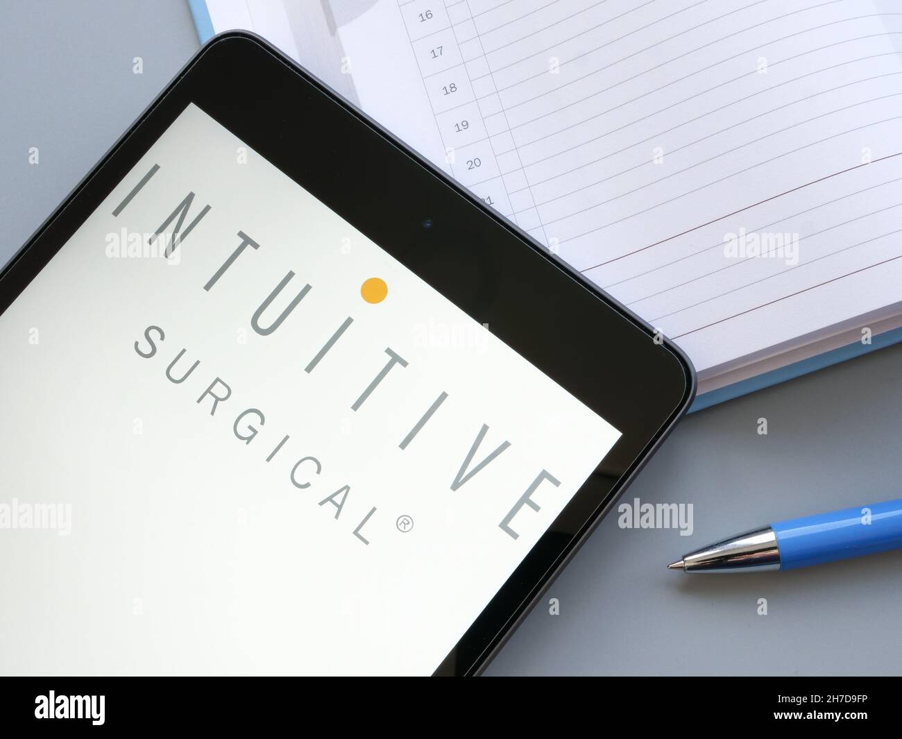 KYIV, UKRAINE - October 21, 2021. Intuitive Surgical Inc logo near pen and notebook. Stock Photo