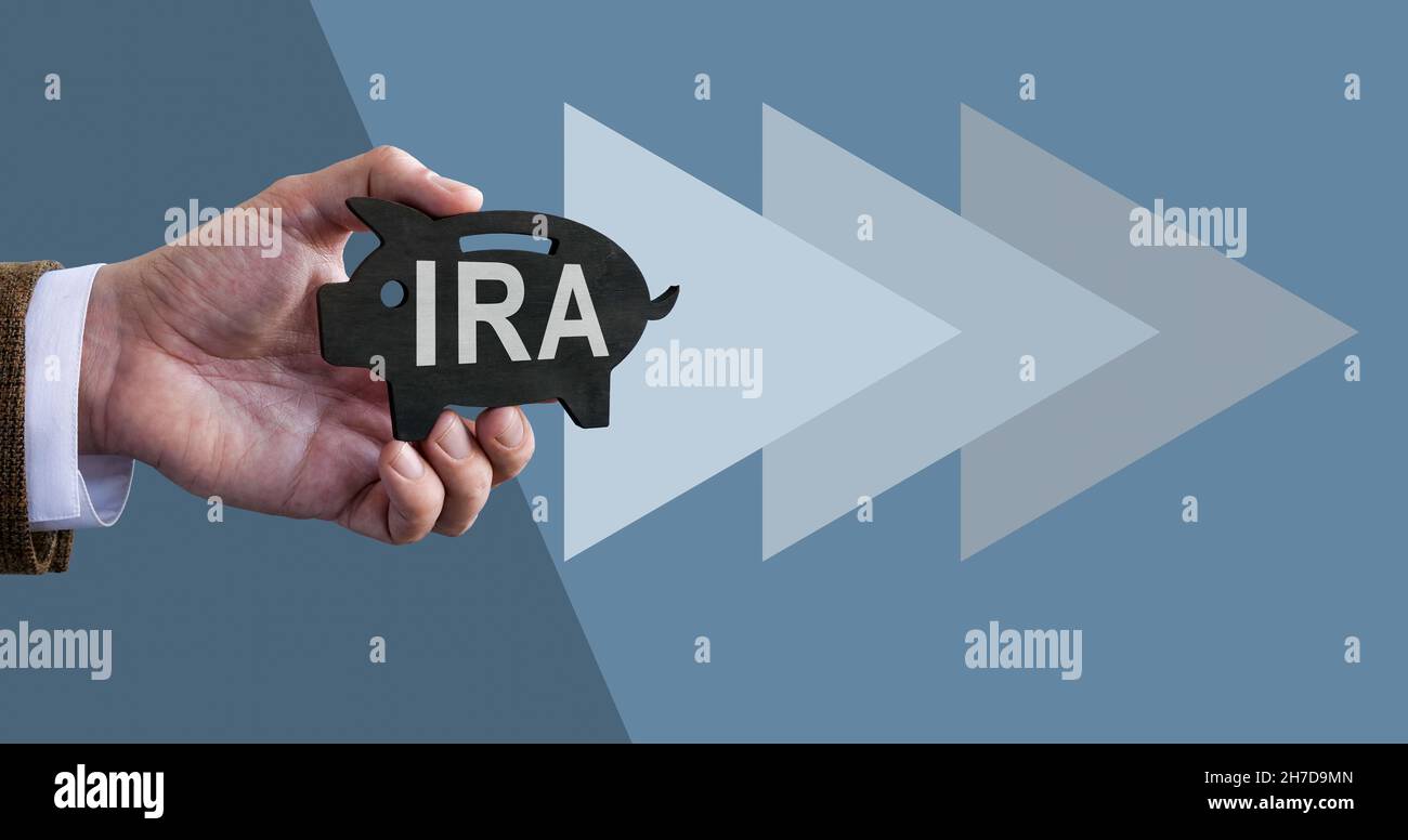 Hand holds piggy bank with IRA individual retirement account. Stock Photo