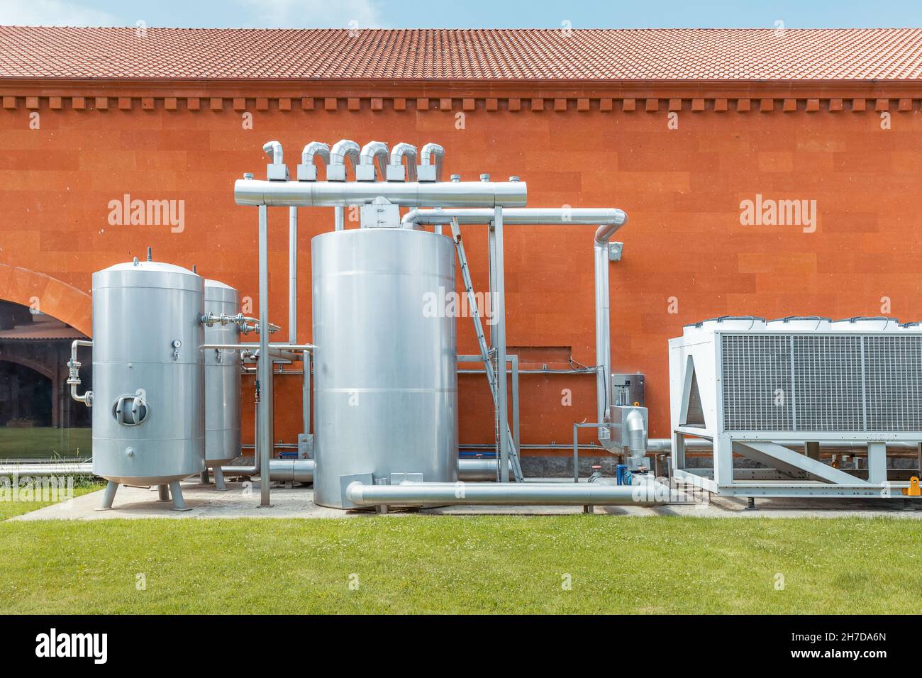 Industrial refrigeration system with compressor and metal tanks outside the wine production plant. Thermovinification and temperature constancy in the Stock Photo