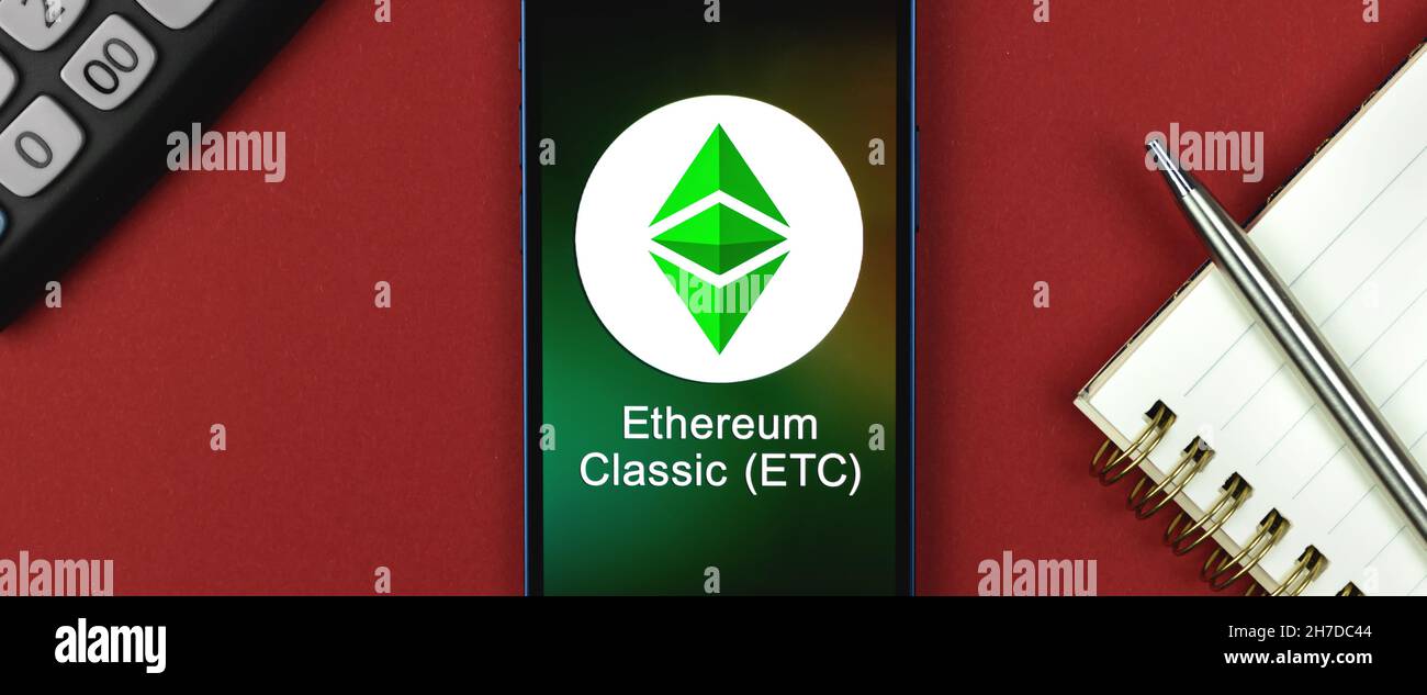 Ethereum Classic ETH symbol. Trade with cryptocurrency, digital and virtual money, banking with mobile phone concept. Business workspace, banner, tabl Stock Photo