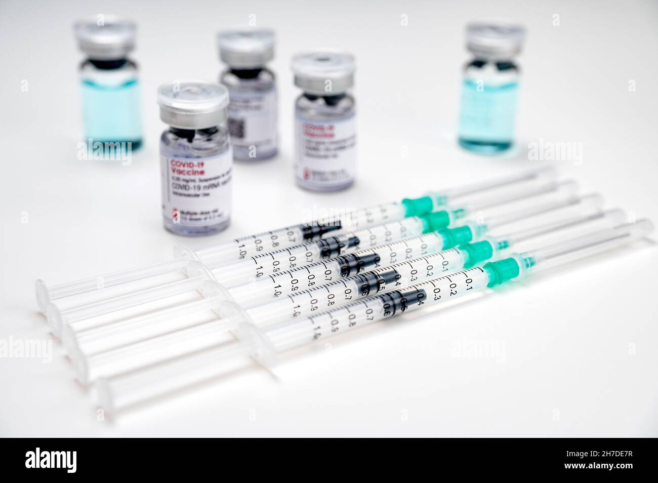 Coronavirus vaccination against SARS-CoV-2 – medical syringes with COVID-19 vaccine and different glass vials in the background. Stock Photo