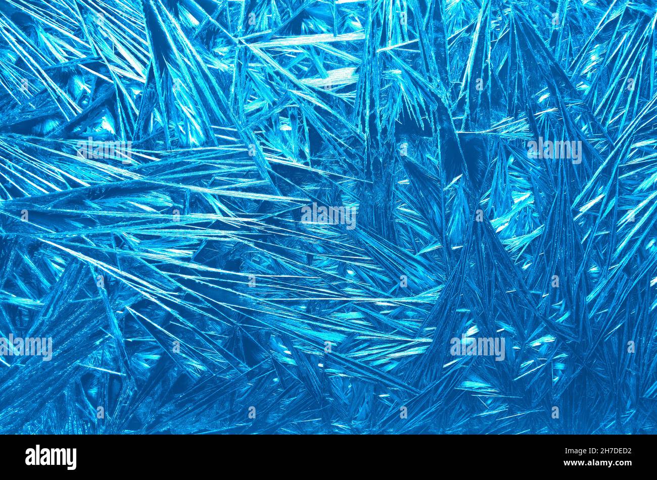 Frost pattern on glass close up - abstract blue winter background. Ice texture - graphic shiny Christmas backdrop - fairy tale of winter wonderland, s Stock Photo