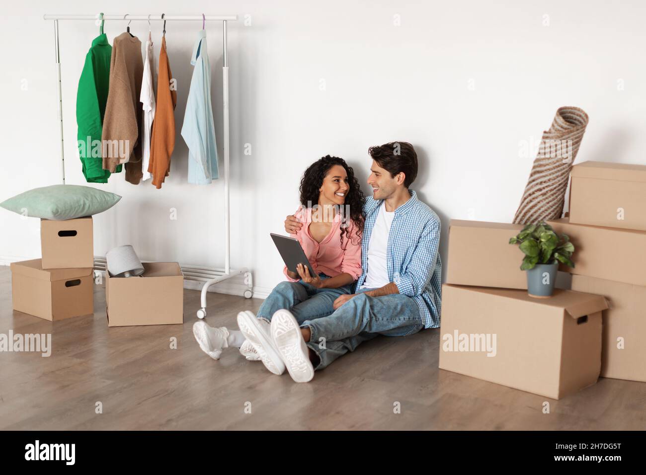 Happy millennial couple using digital tablet after relocation Stock Photo