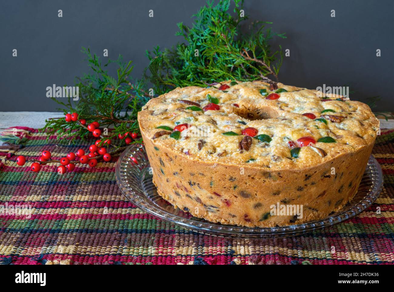 Traditional homemade fruitcake decorated with pecans and candied cherries. Stock Photo