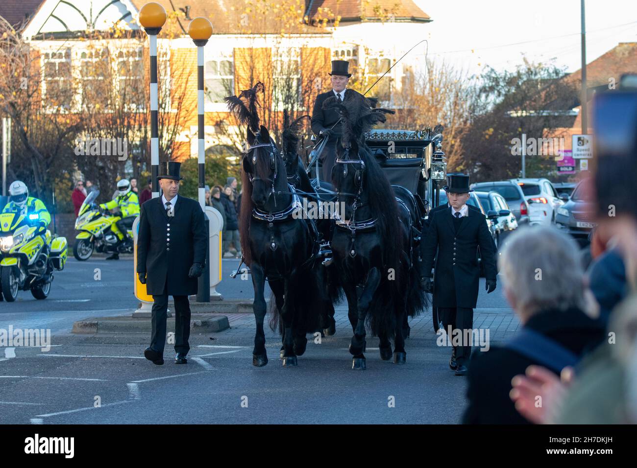 SOUTHEND, ENGLAND, NOVEMBER 22ND 2021, Members of the public align the streets outside Southend West Conservative Association's Iveagh Hall to pay their respects as a horse-drawn hearse carrying the coffin of murdered Southend West MP Sir David Amess stops as a part of it procession. Credit: Lucy North/Alamy Live News Stock Photo