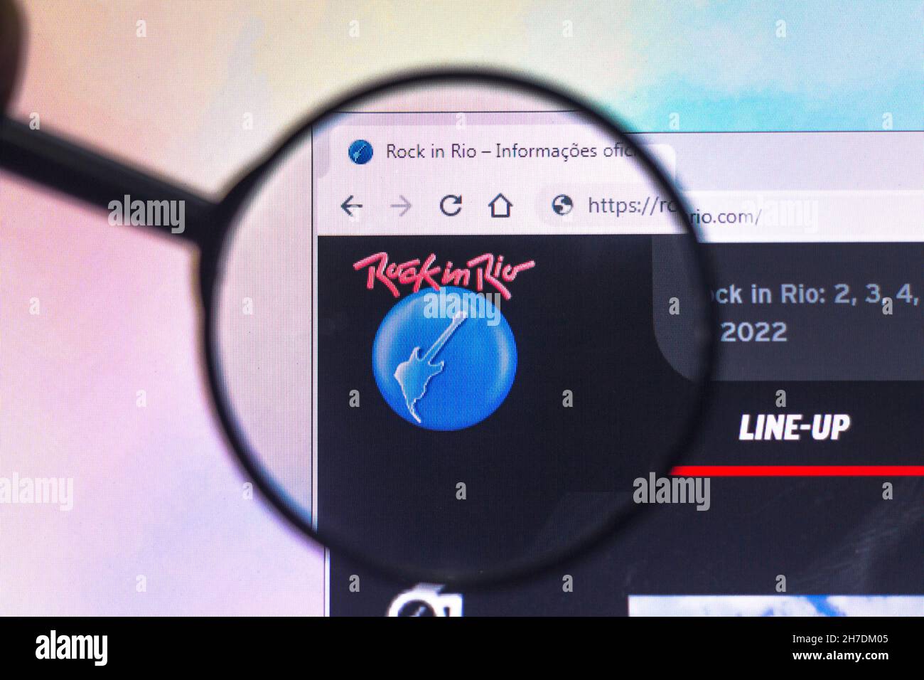 In this photo illustration, a Rock in Rio logo seen displayed on a computer screen through a magnifying glass. Stock Photo