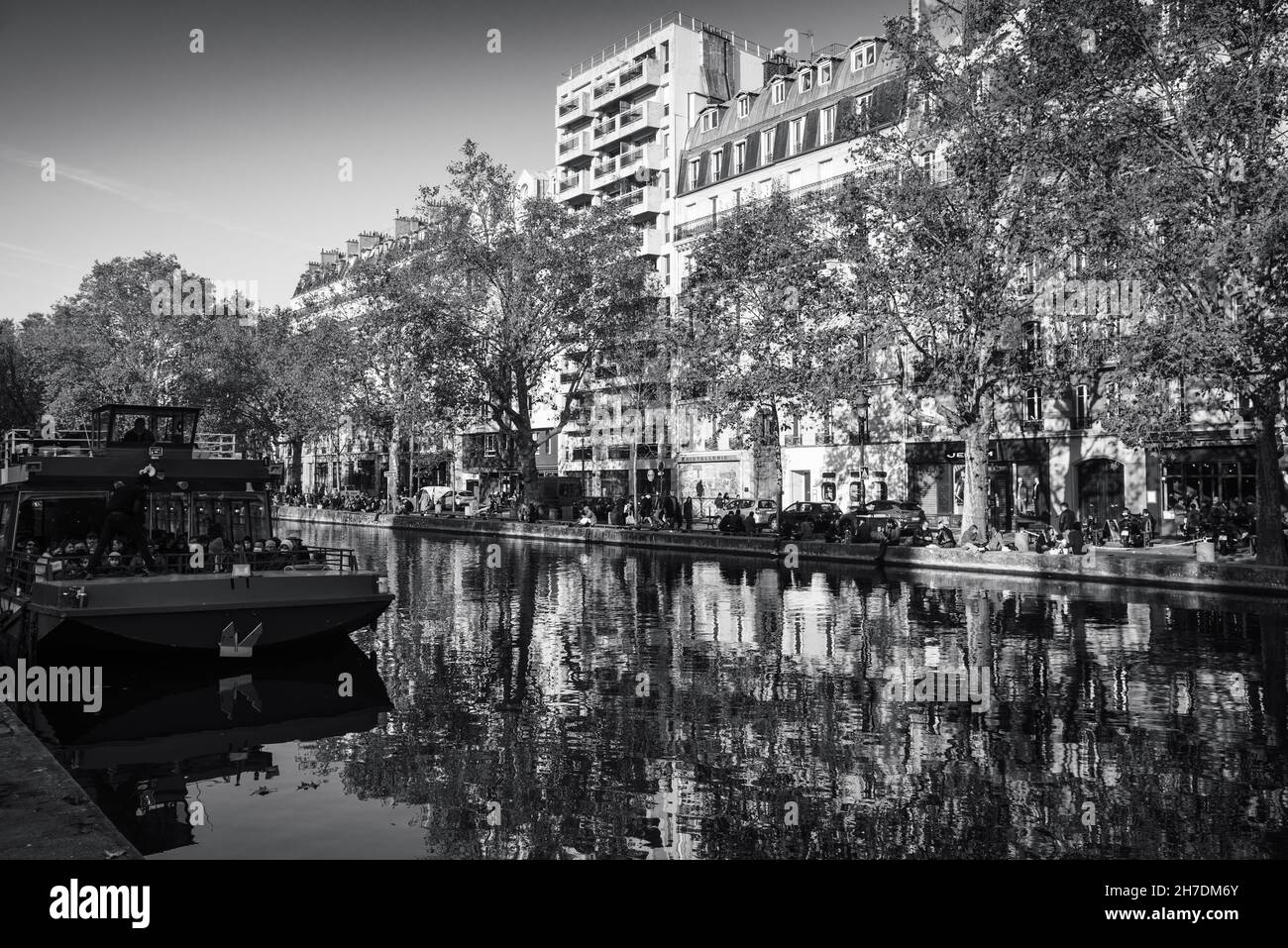 Boat on Canal Saint-Martin in autumn. Paris, France. Beautiful reflection. Black white historic photo Stock Photo