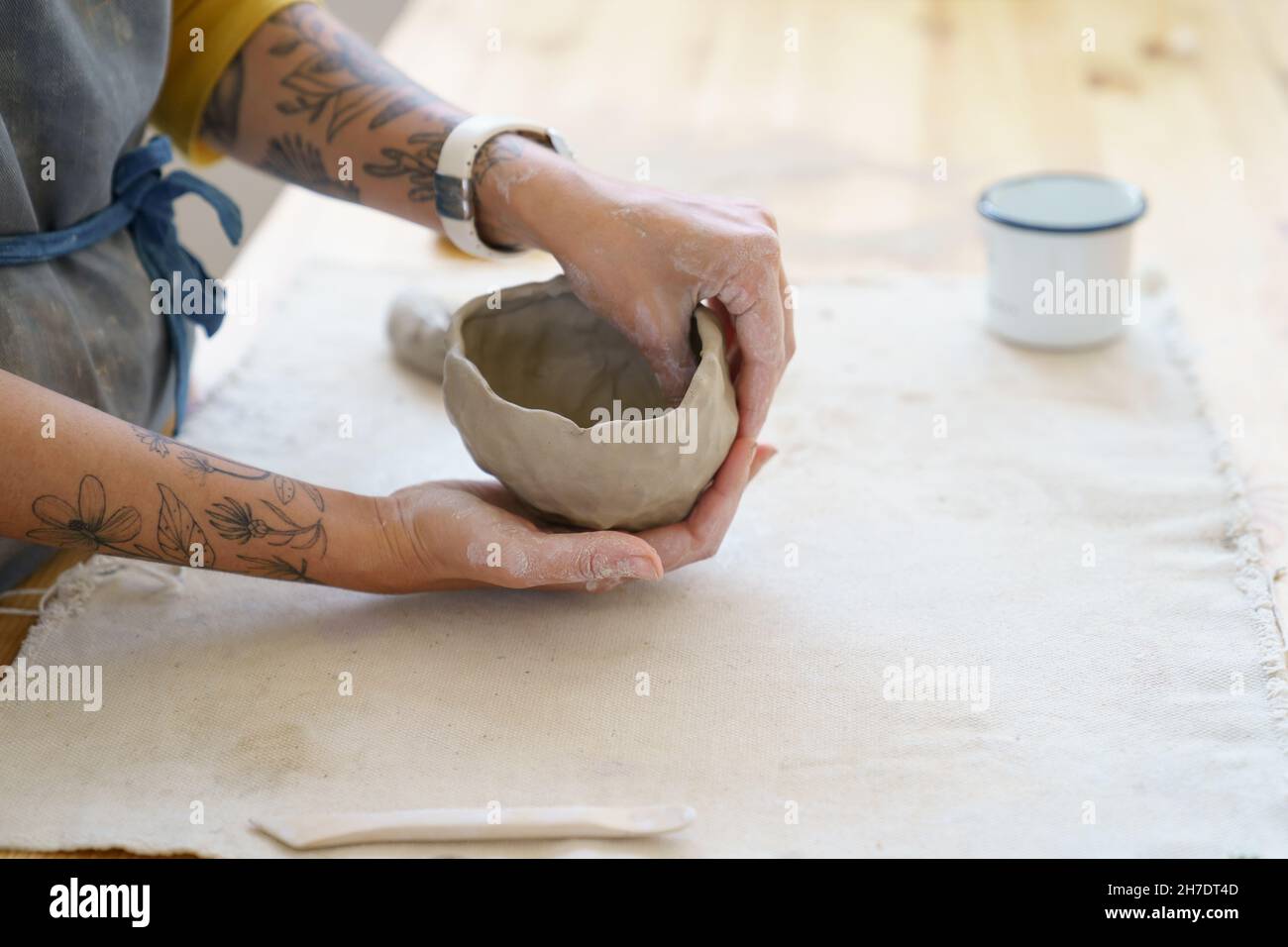 Creating pottery table in ceramic studio with master hands shaping